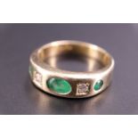 A contemporary emerald and diamond ring, comprising an oval emerald of approx 0.5 ct, and two