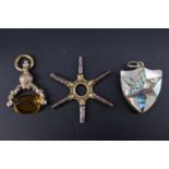 A Victorian mother-of-pearl and abalone veneered gilt metal shield shaped watch chain fob locket