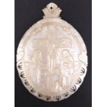 A carved mother-of-pearl pilgrim plaque depicting the Crucifixion, 7 cm x 5 cm