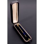 A cased Edwardian sapphire and 15 ct yellow metal stick pin, having a 3 mm brilliant set in a