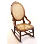 A Victorian cane-seated rocking chair