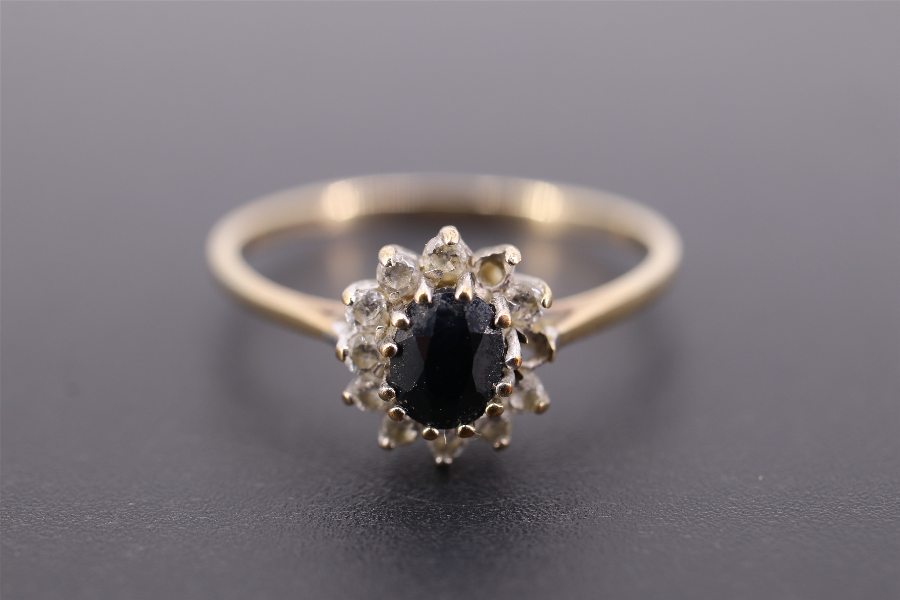 A sapphire, white paste and 9 ct gold flowerhead cluster ring, the oval sapphire of approx 0.3 ct, - Image 2 of 4