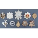 A small group of British army and other cap badges including a Shropshire Yeomanry badge