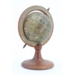 A vintage table top terrestrial globe, being a printed paper covered globe on a turned walnut stand,