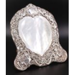 A late 19th / early 20th Century silver-faced dressing table mirror, having a heart-shaped bevel-