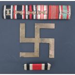 Two German Third Reich medal ribbon bars together with a swastika device cut from a stamped brass