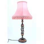 An Indian hand painted floral turned and carved wood table lamp, having a triple helical stem, 45 cm