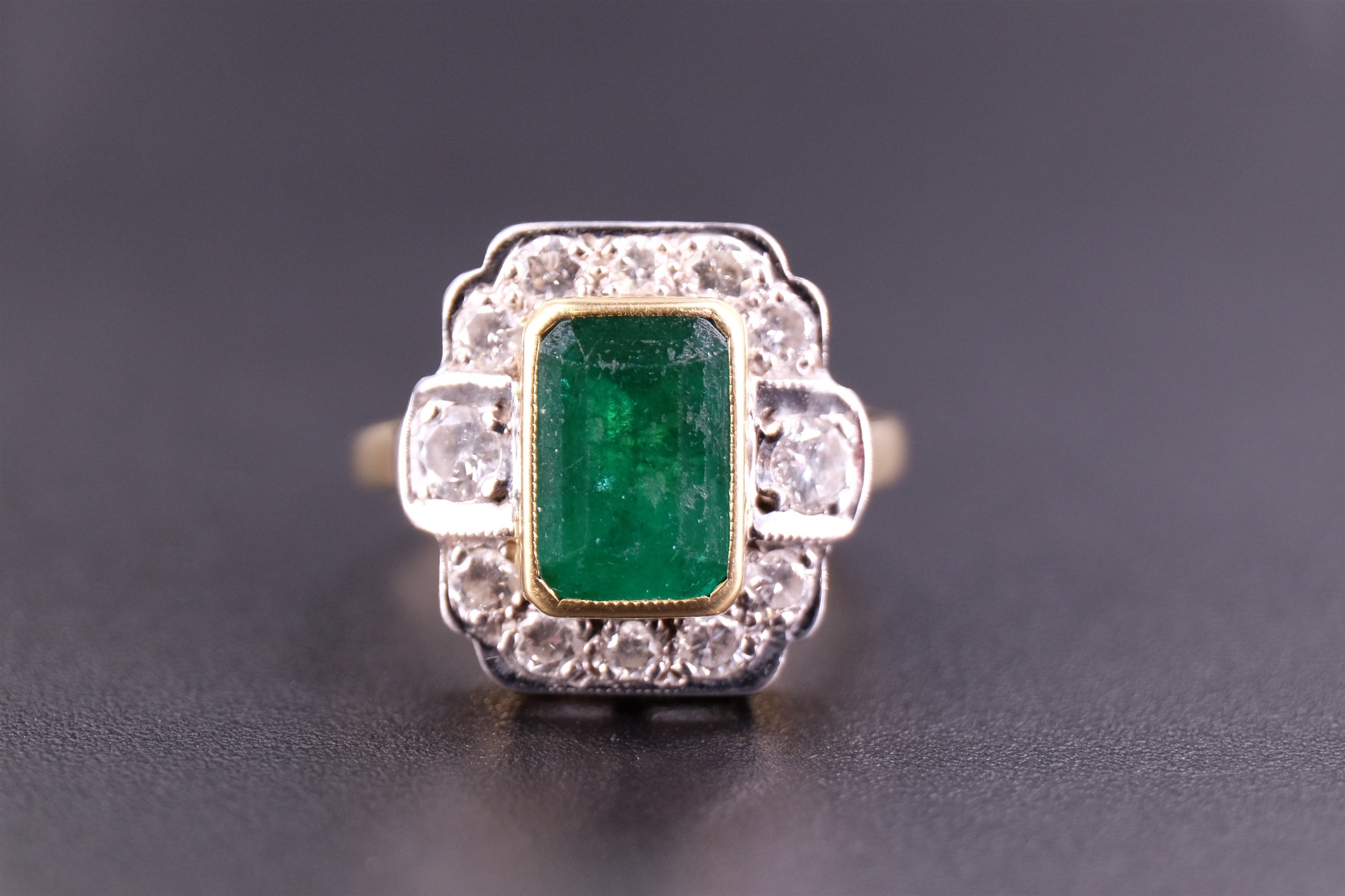 An Art Deco emerald and diamond ring, the central 'emerald' cut 1.75 carat emerald set in a yellow - Image 2 of 4