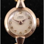 A 1950s Lanco 9 ct gold wristlet watch, having a 15 jewel movement and a silver dial, in a gold case