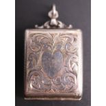 An Edwardian silver fob stamp case, cushion-shaped and foliate scroll engraved, the obverse
