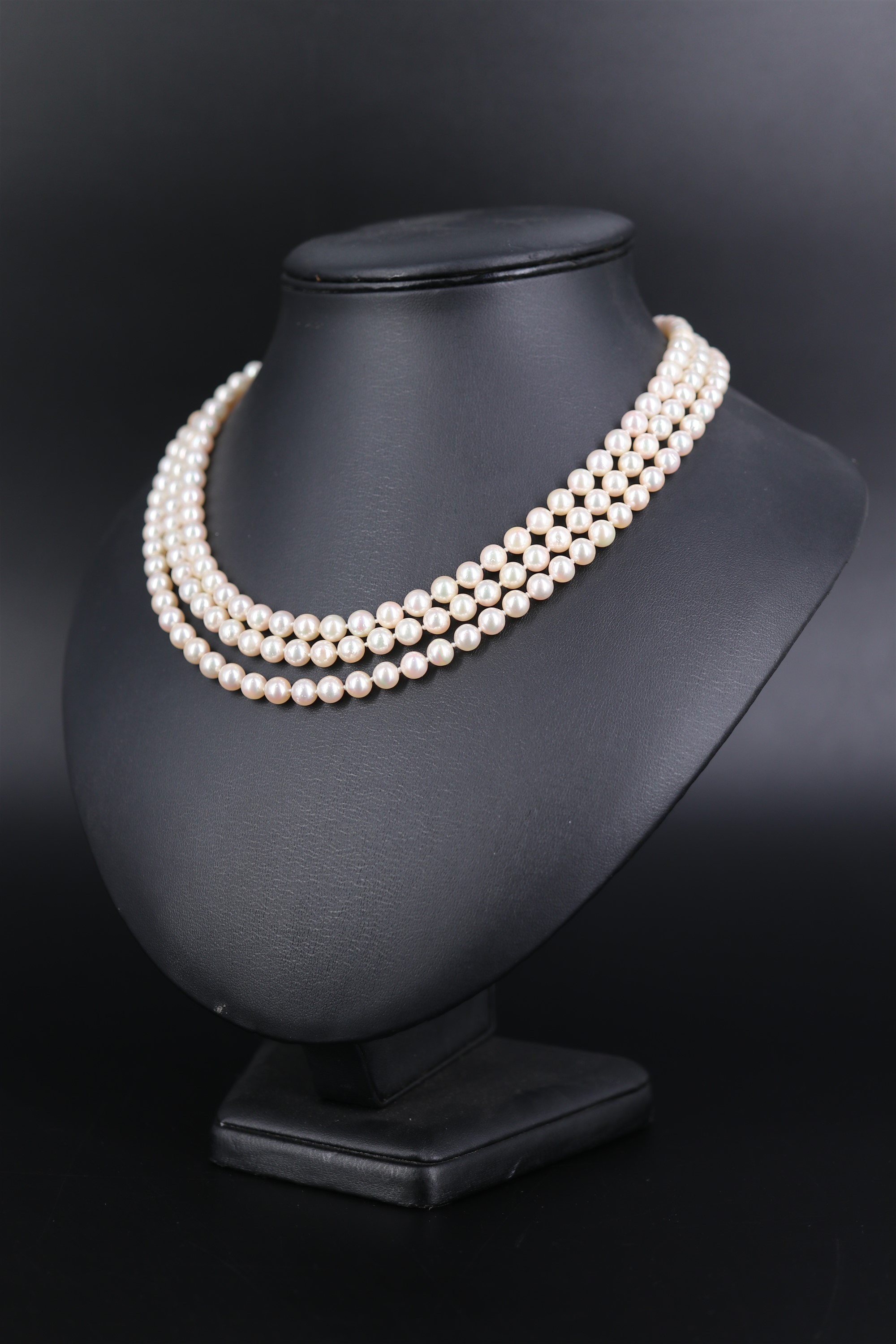A three-strand necklace of uniform Takara cultured pearls, having an 18 ct gold clasp set with a