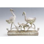 A cast aluminium garden sculpture of two storks with horseshoes, 34.5 cm