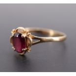 A vintage almandine and 9 ct gold ring, the oval cut stone of approx 1 ct claw set within a