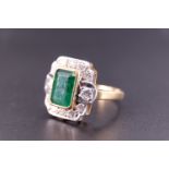 An Art Deco emerald and diamond ring, the central 'emerald' cut 1.75 carat emerald set in a yellow