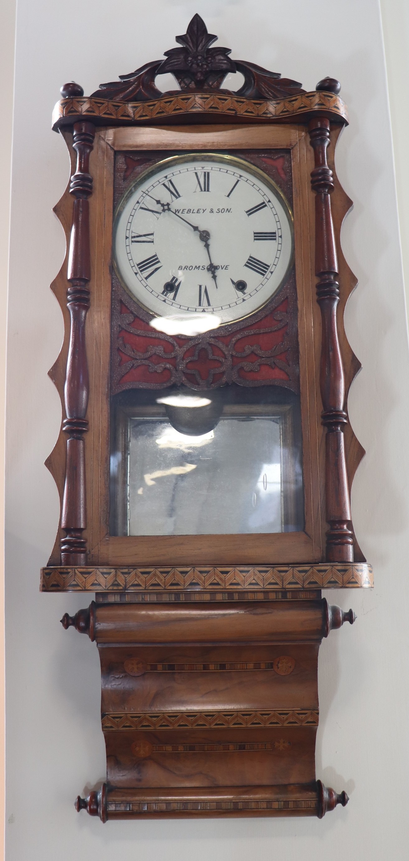 An early 20th Century parquetry inlaid walnut American wallclock, having a later face marked '