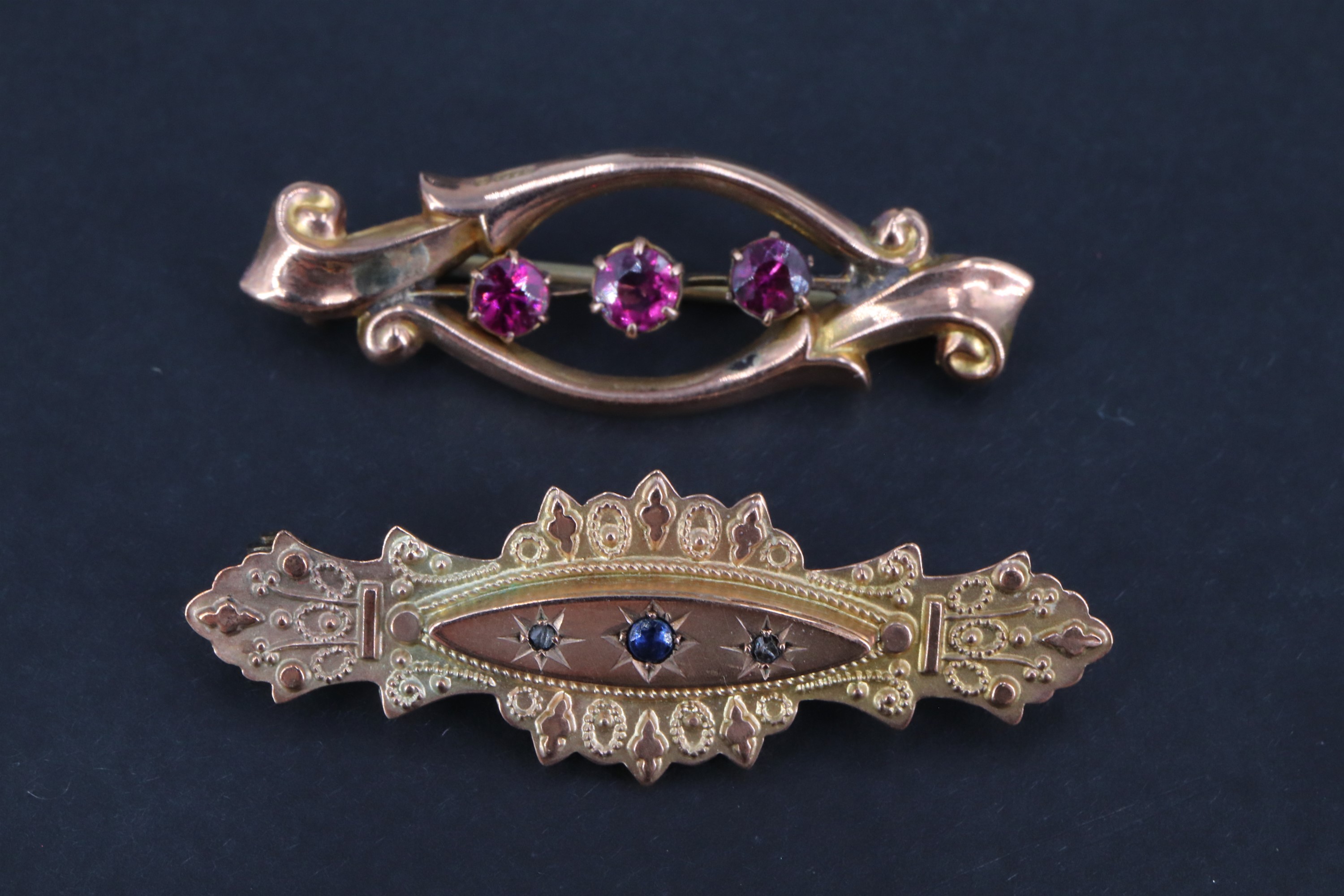 Two late 19th / early 20th Century 9 ct gold brooches, respectively set with three almandines open