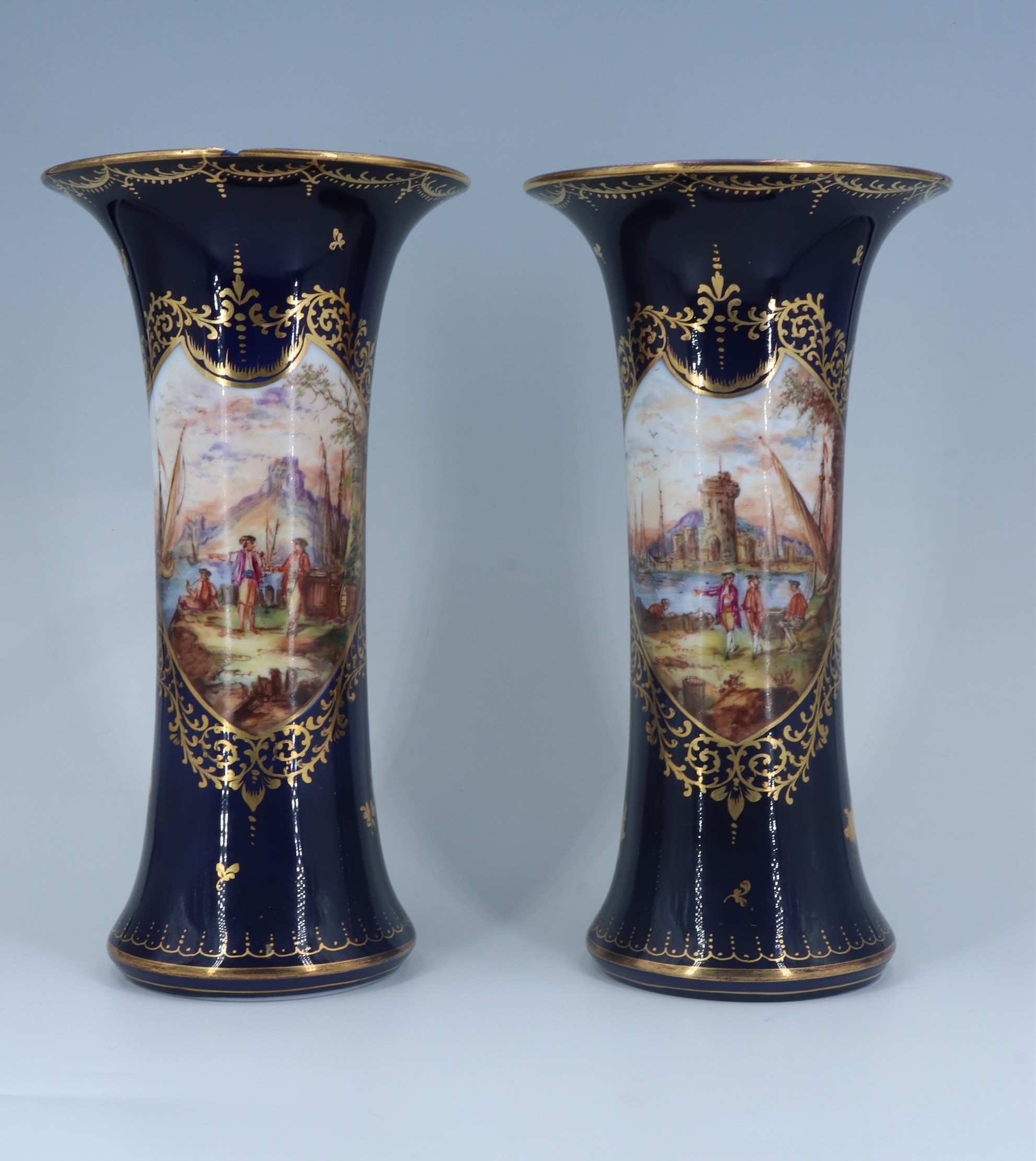 A pair of late 19th / early 20th Century Dresden cobalt blue porcelain vases each of waisted form