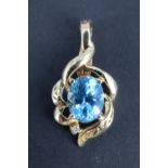 A late 20th Century topaz and diamond pendant, the 10 x 8 mm oval topaz surrounded by asymmetric