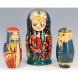 A vintage Russian Martyoshka doll together with two others decorated as naval officers and suit of