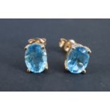 A pair of late 20th Century topaz stud earrings, each having an 8 x 6 mm oval stone set on a