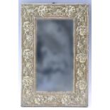 A 1930s brass framed mirror, having embossed floral decoration, 40.5 x 27 cm overall