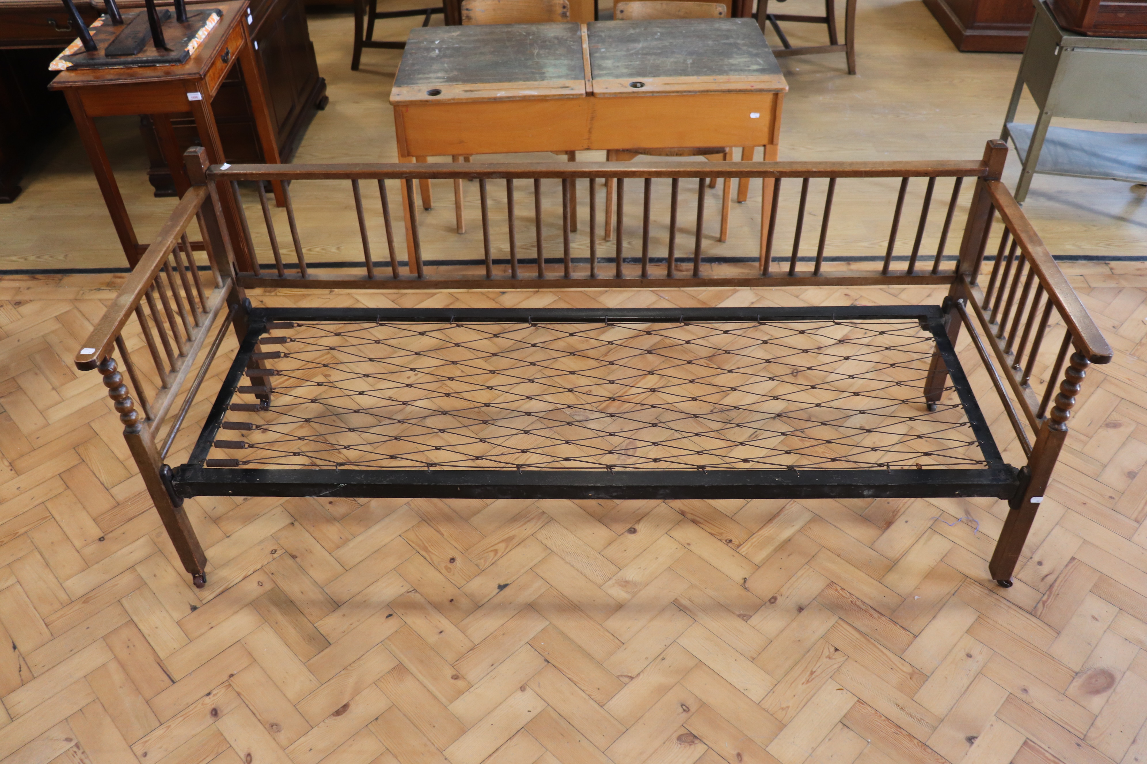 An early 20th Century folding sprung-iron-framed turned wood day bed, (some insect damage)