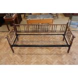 An early 20th Century folding sprung-iron-framed turned wood day bed, (some insect damage)