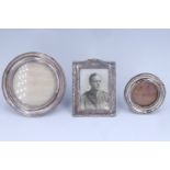 Three George V silver faced photograph frames, comprising two circular and one oblong with a