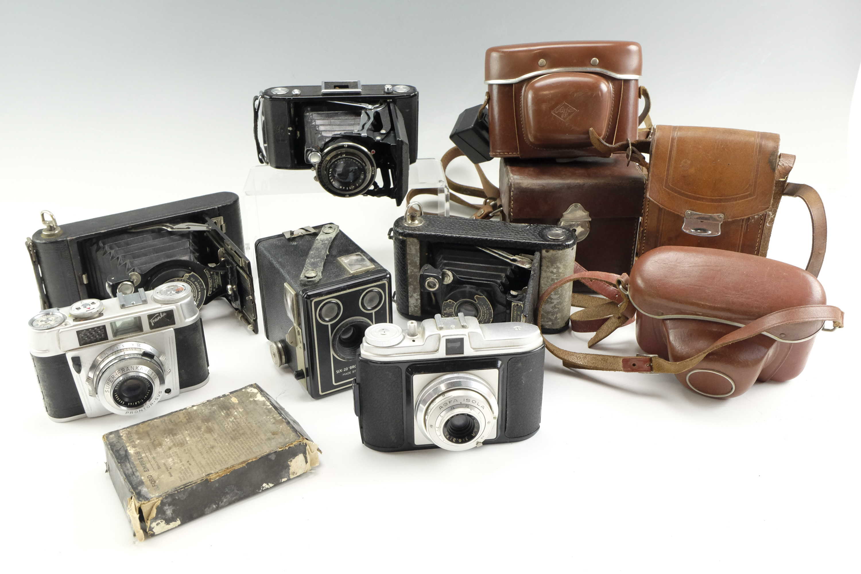 A group of vintage film cameras, including a No 1A Pocket Kodak, a Zeiss Ikon Klio, an Agfa Isola, a