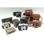 A group of vintage film cameras, including a No 1A Pocket Kodak, a Zeiss Ikon Klio, an Agfa Isola, a