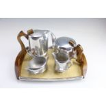 A 1950s Picquot ware magnalium and teak four piece teaset on conforming tray