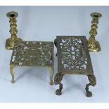 Two early 20th Century brass trivets, one bearing Royal arms, and a pair of brass candlesticks,