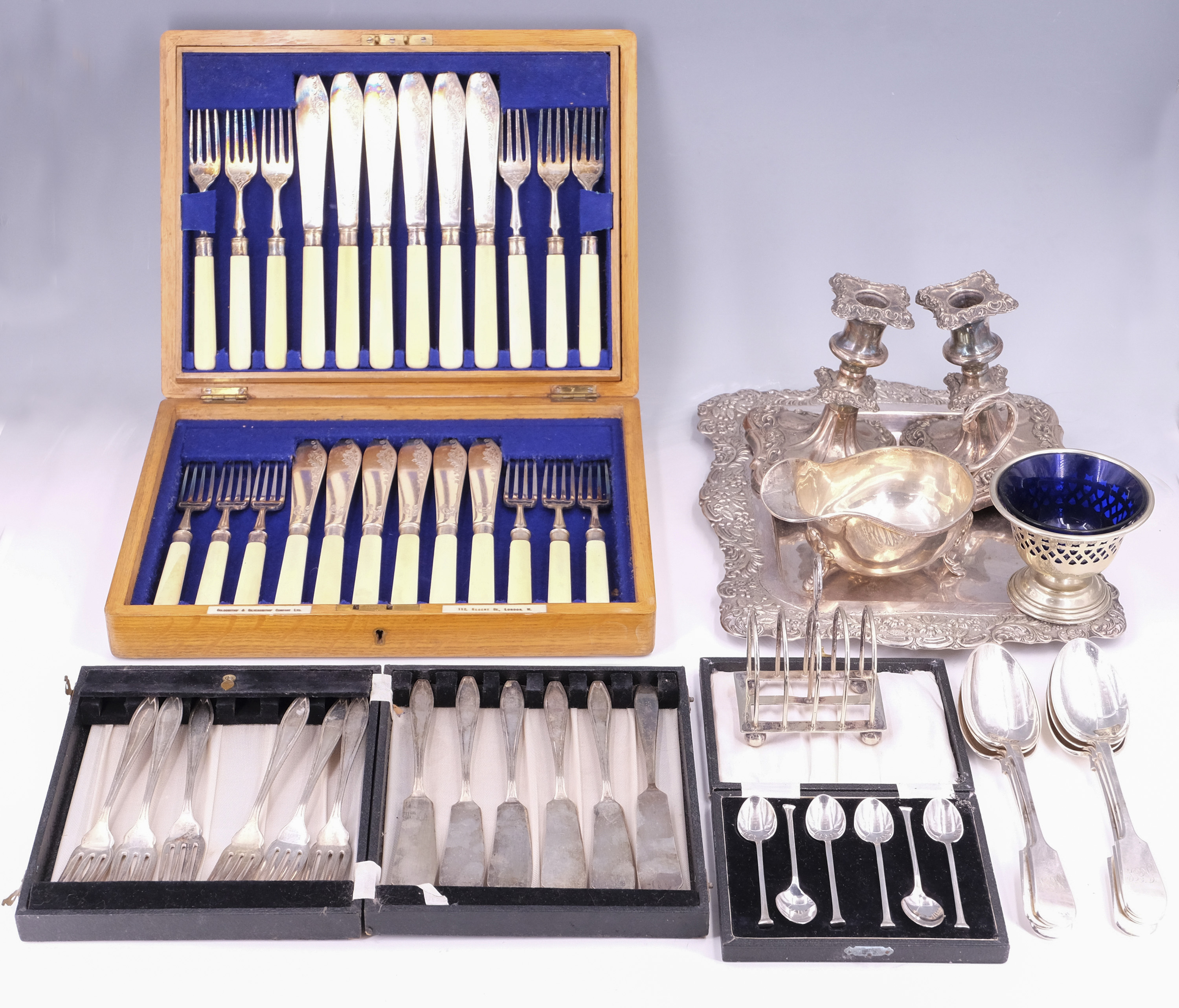 Vintage cases sets of electroplate cutlery, Victorian electroplate candlesticks, a tray, toast