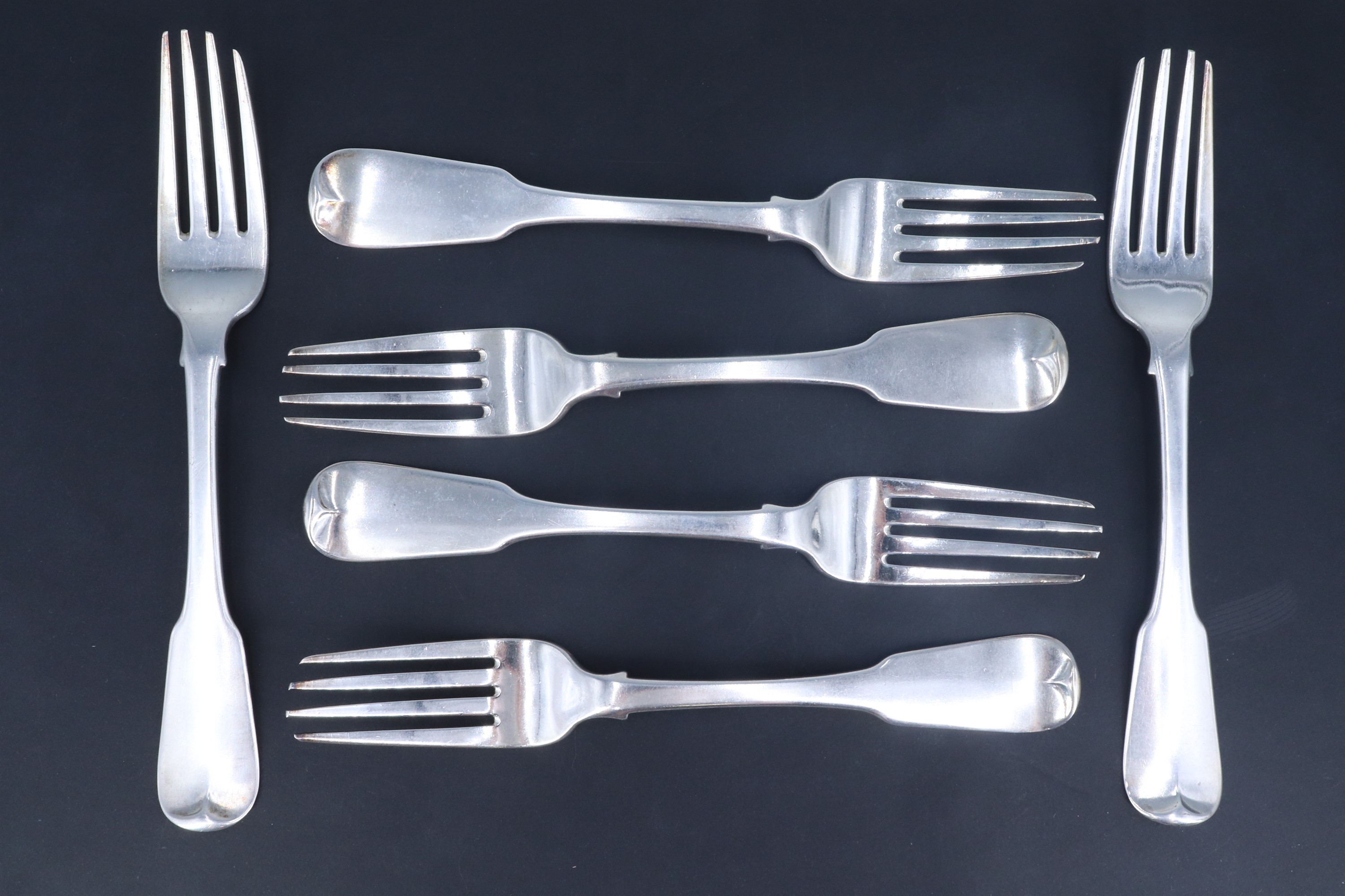 A set of six George IV Irish silver fiddle pattern table forks, each bearing engraved crest,