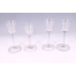 Four Georgian plain-stemmed wine glasses, each having etched conical-funnel bowl and folded foot,