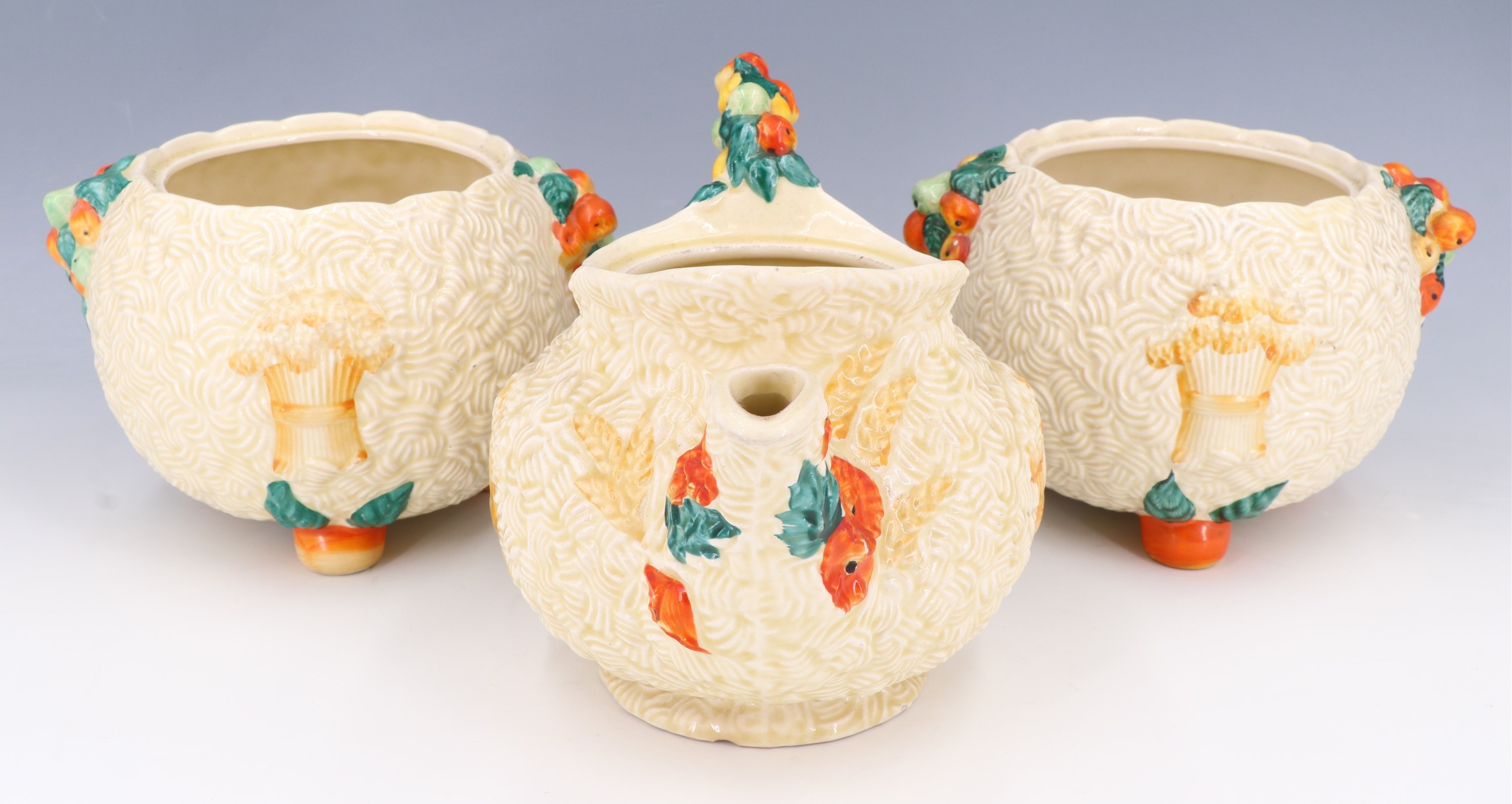 Three items of Clarice Cliff Celtic Harvest ceramics, comprising a teapot (68A) and two storage jars