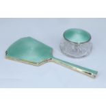 A 1930s enamelled silver backed hand mirror and conforming cut glass dressing table pot, William