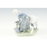 An early 20th Century Royal Copenhagen figurine of a milk maid weaning a calf, incised signature