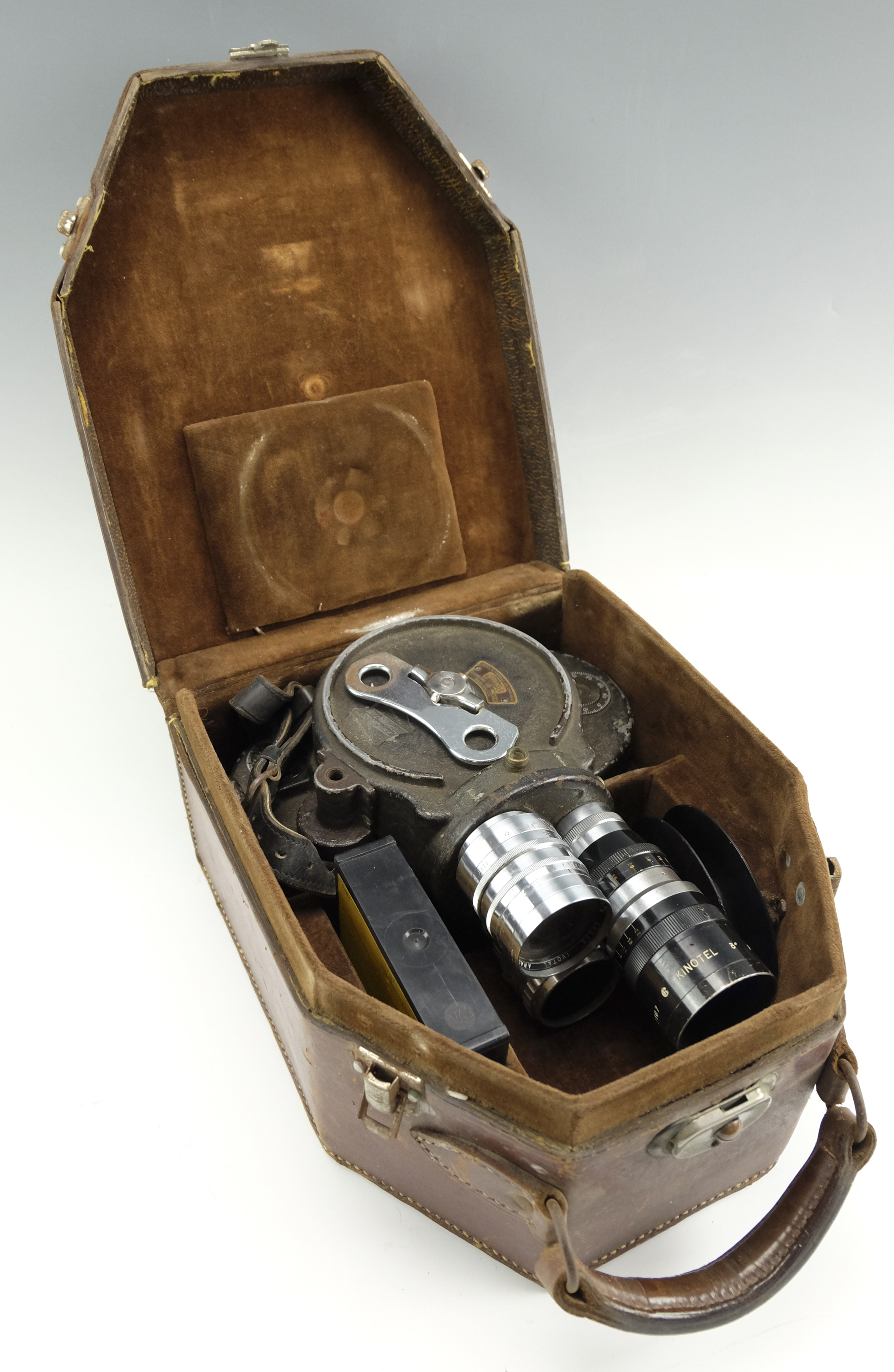 A cased Bell & Howell Filmo 70-DA 16 mm cine camera body, having a three lens turret mounted with