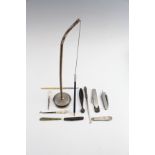 A group of collectibles, including pocket knives, button hooks, a fleam, a counter-top pen holder, a