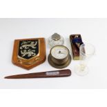 A vintage letter opener from the teak of HMS Sesame, a glass inkwell, a measuring glass, a small