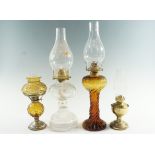 Three early 20th Century bedroom oil lamps and a spirit lamp, comprising a brass and two moulded