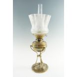 An early 20th Century brass oil lamp, having a triform base holding a removable font with a