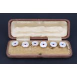 A cased set of six early 20th Century mother-of-pearl waistcoat buttons, each having a concave front