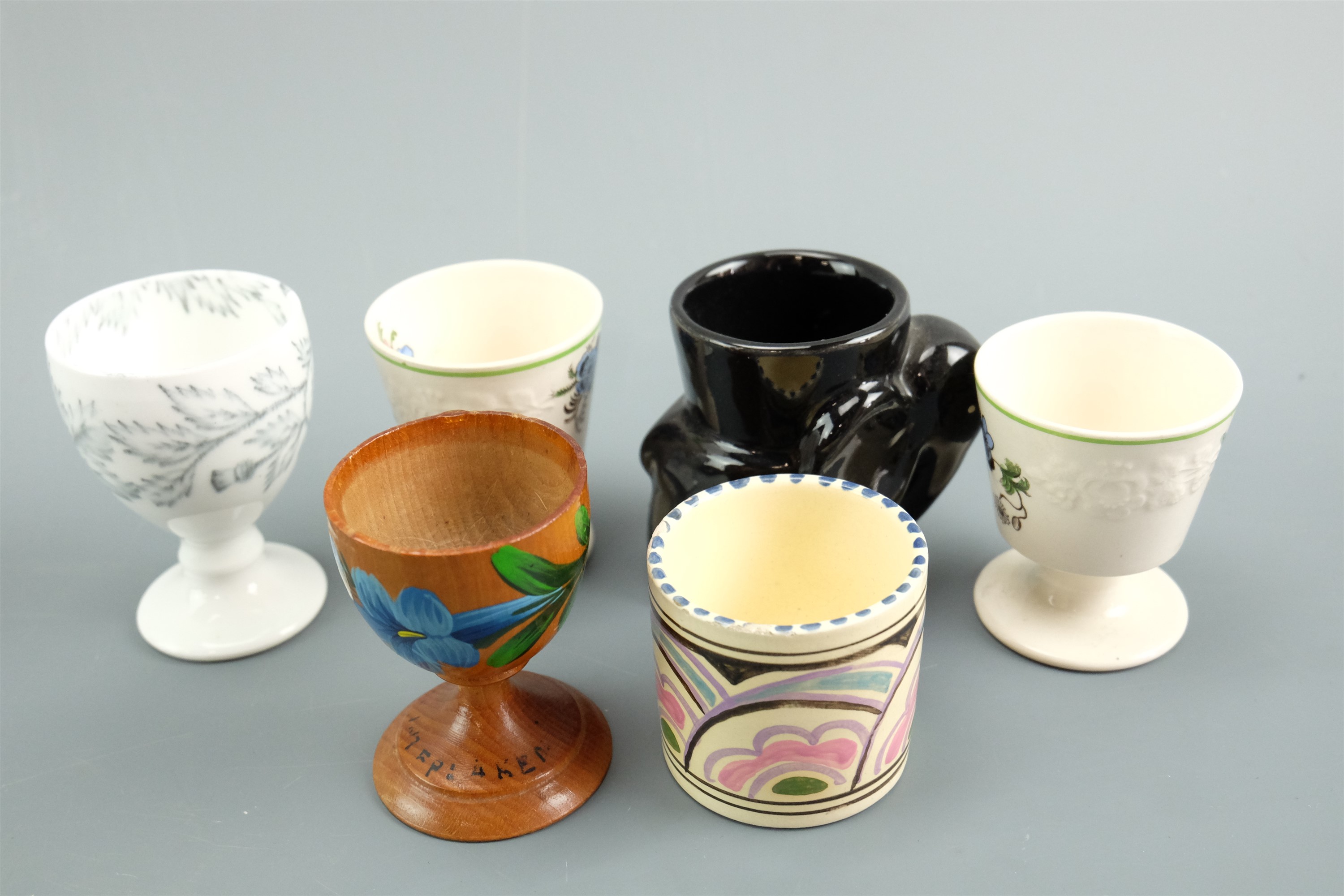 A large quantity of ceramic, electroplate and treen egg cups