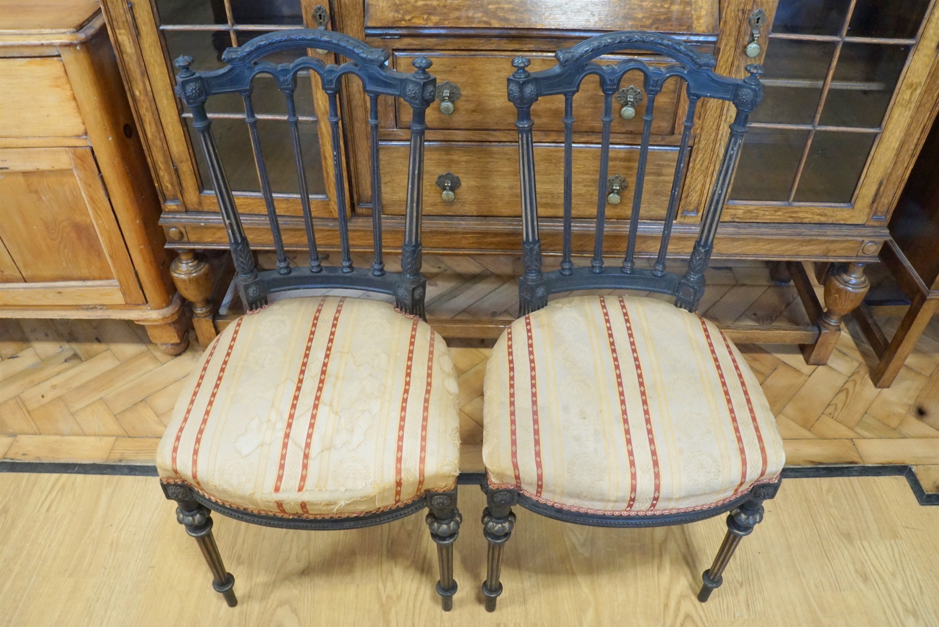 A pair of late 19th / early 20th Century Louis XVI style ebonised and and parcel gilt parlour