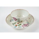 An 18th Century Worcester tea bowl and saucer, in the Harvest pattern having polychrome flowers