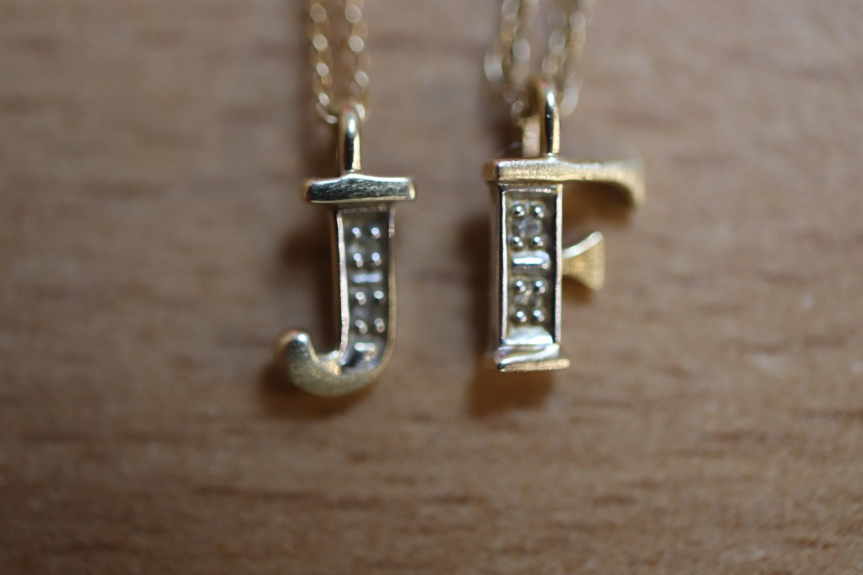 Two late 20th Century 14 ct yellow metal initial pendant necklaces, comprising a 'J' and an 'F' both