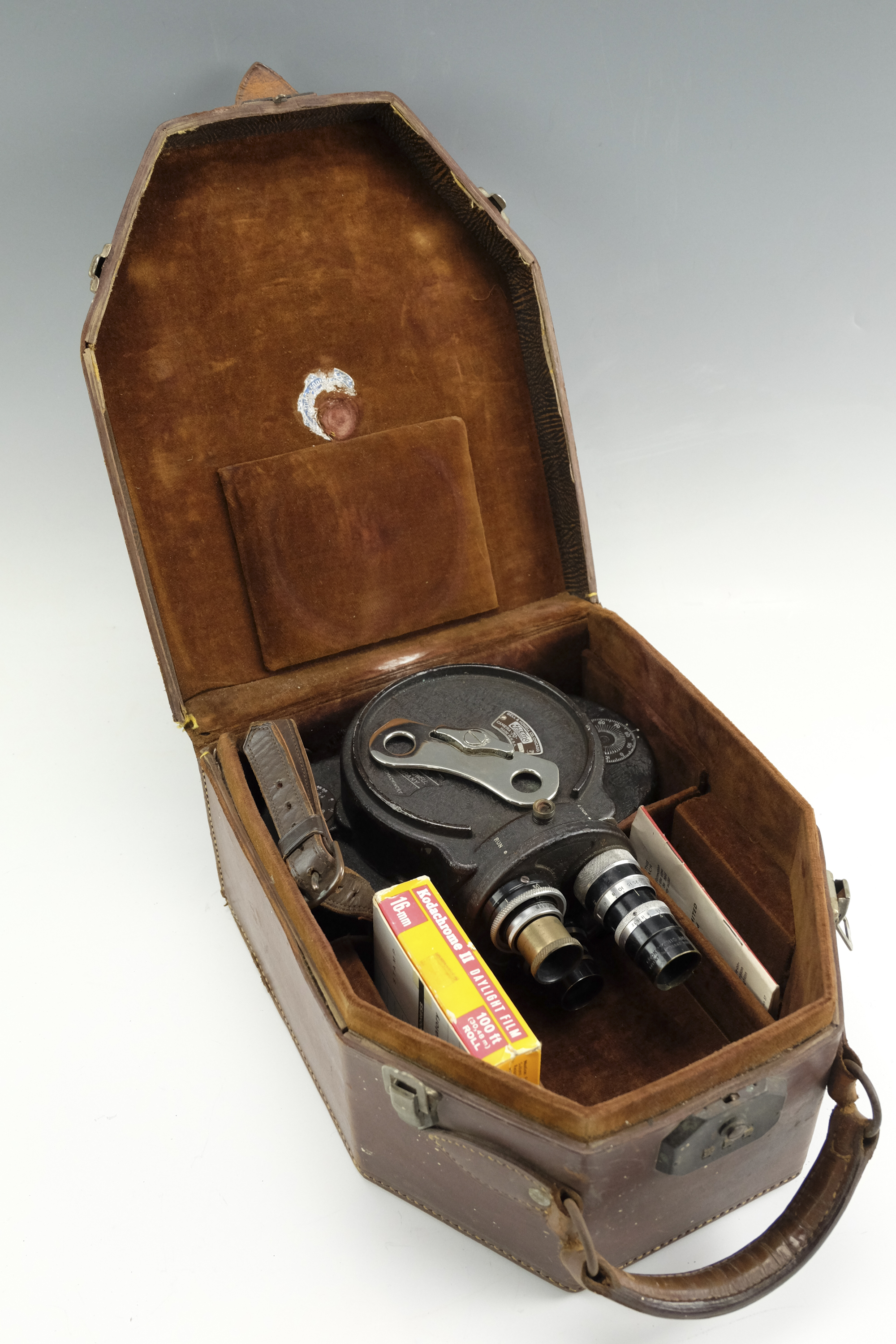 A cased Bell & Howell Filmo 70-DA 16 mm cine camera body, having a three lens turret mounted with