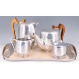 A 1950s Picquot ware magnalium and teak four piece teaset on conforming tray